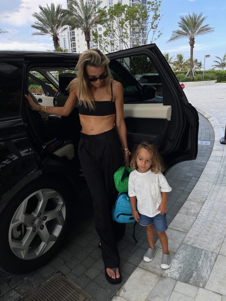 tiago micro top, revolve black cropped top, revolve ambassador, zara black trousers, bottega veneta green jodie bag, prada sunglasses, past midnight necklace, bottega veneta ring, NBD top, the row shoes, toddler style inspo