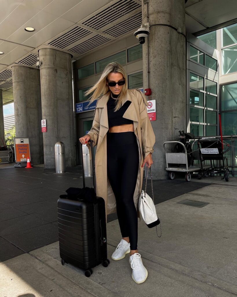 the frankie shop trench coat, trench coat, alo yoga leggings, black leggings, alo yoga black legging, chanel backpack, away carry on, away luggage, best carry on, hanes x karla cropped tee, amazon tshirt, electric picks, yeezys, airport outfit, sunglass hut, prada sunglasses